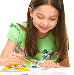 Image showing Little girl is painting with gouache