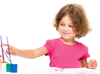 Image showing Little girl is painting with gouache