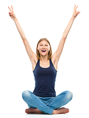 Image showing Young happy woman is sitting on the floor