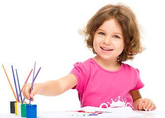 Image showing Little girl is painting with gouache