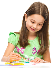 Image showing Little girl is painting with gouache