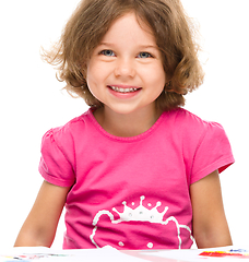 Image showing Little girl is painting with gouache