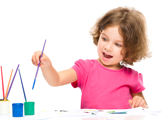 Image showing Little girl is painting with gouache