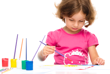 Image showing Little girl is painting with gouache