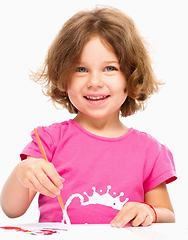 Image showing Little girl is painting with gouache