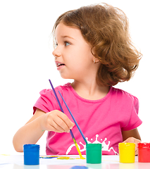 Image showing Little girl is painting with gouache