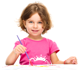 Image showing Little girl is painting with gouache