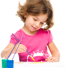 Image showing Little girl is painting with gouache