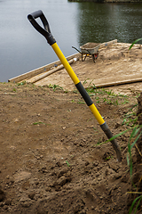 Image showing Wheelbarrow and shovel for construction in site building area.