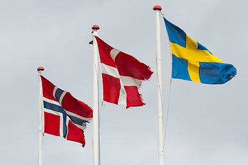 Image showing Three scandidavian flags in the wind against the sky