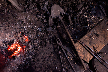 Image showing top view of traditional blacksmith furnace with burning fire