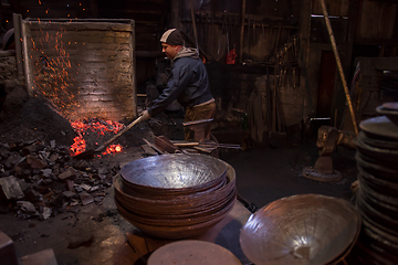 Image showing young traditional Blacksmith working with open fire