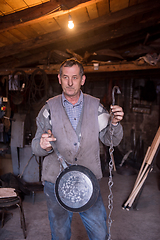 Image showing A blacksmith worker showing handmade products ready for sale