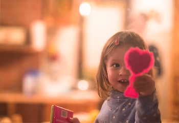 Image showing little cute girl playing near the window