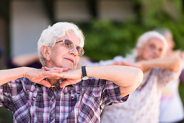 Image showing senior woman exercising with friends