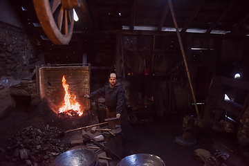 Image showing young traditional Blacksmith working with open fire