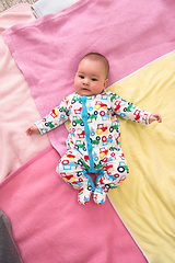 Image showing top view of newborn baby boy lying on colorful blankets