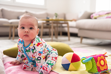 Image showing newborn baby boy sitting on colorful blankets