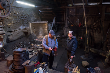 Image showing portrait of two generations traditional blacksmith