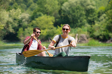 Image showing couple of explorers conoining on wild river