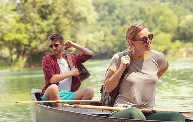 Image showing couple of explorers conoining on wild river