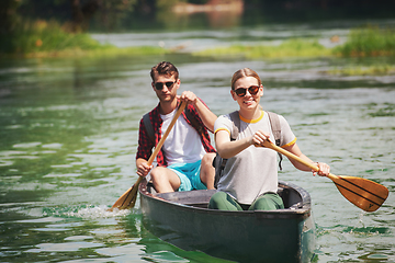 Image showing couple of explorers conoining on wild river