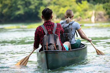 Image showing couple of explorers conoining on wild river