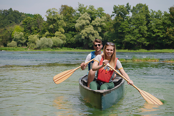 Image showing couple of explorers conoining on wild river