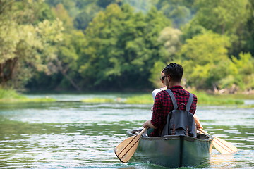 Image showing couple of explorers conoining on wild river