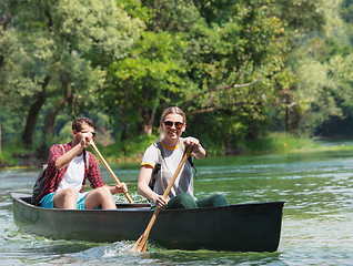 Image showing couple of explorers conoining on wild river