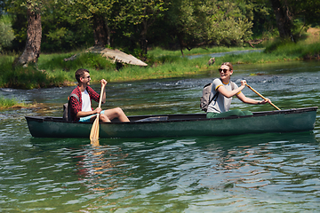 Image showing couple of explorers conoining on wild river