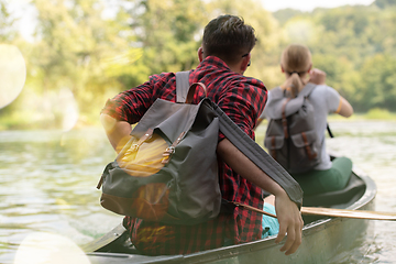 Image showing couple of explorers conoining on wild river