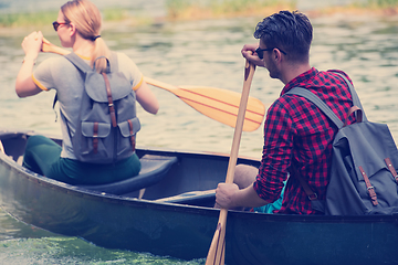 Image showing couple of explorers conoining on wild river