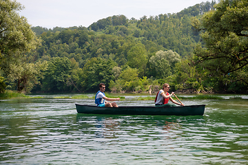 Image showing couple of explorers conoining on wild river