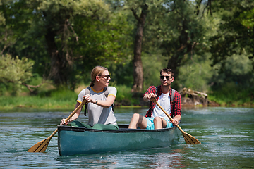 Image showing couple of explorers conoining on wild river