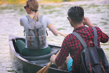 Image showing couple of explorers conoining on wild river