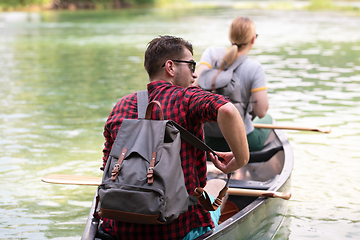 Image showing couple of explorers conoining on wild river