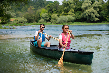 Image showing couple of explorers conoining on wild river