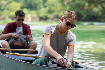 Image showing couple of explorers conoining on wild river