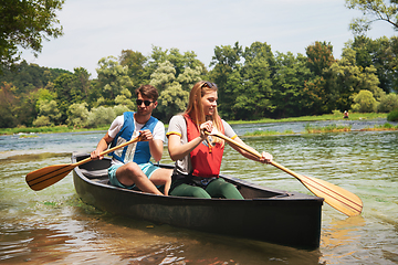 Image showing couple of explorers conoining on wild river