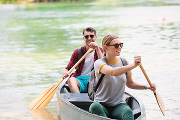 Image showing couple of explorers conoining on wild river