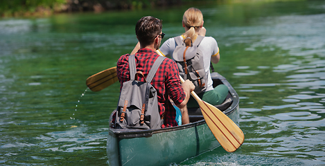 Image showing couple of explorers conoining on wild river