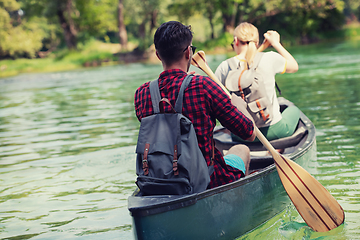 Image showing couple of explorers conoining on wild river