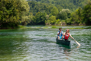 Image showing couple of explorers conoining on wild river