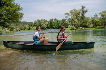 Image showing couple of explorers conoining on wild river