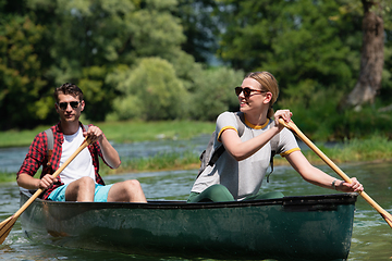 Image showing couple of explorers conoining on wild river