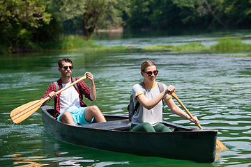 Image showing couple of explorers conoining on wild river