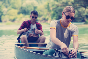 Image showing couple of explorers conoining on wild river