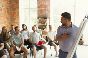 Image showing Male speaker giving presentation in hall at university workshop