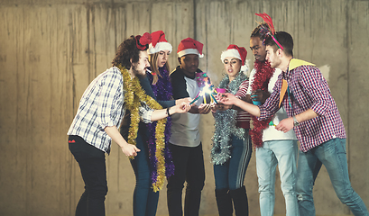 Image showing multiethnic group of casual business people lighting a sparkler